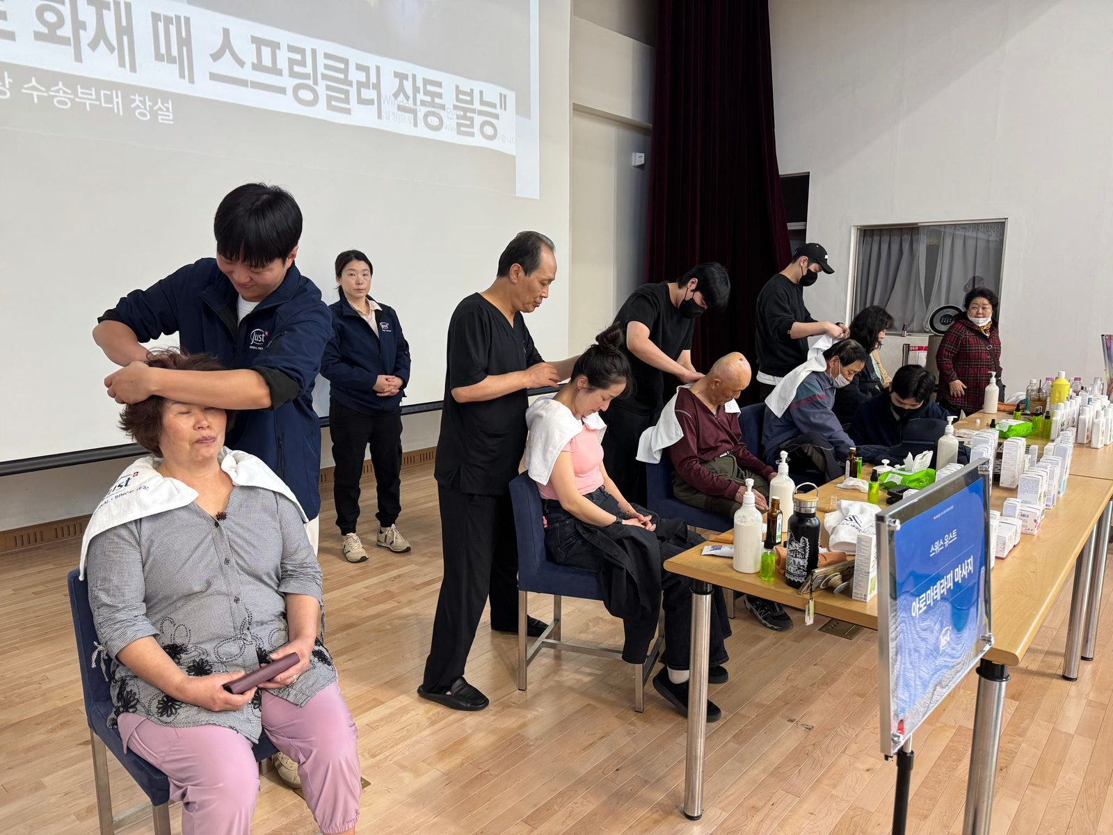 봉사 현장에서 아로마테라피 마사지를 진행하는 모습